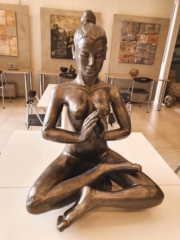 Figura feminina sentada em bronze na galeria