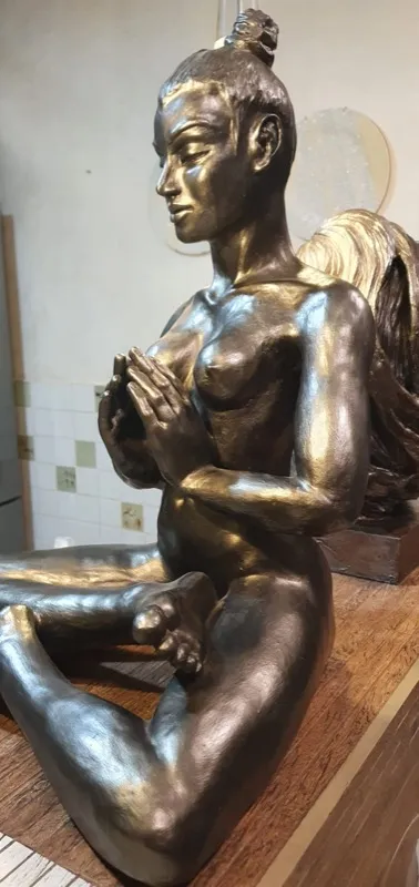 Figura feminina em bronze — close-up lateral