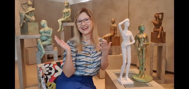 Norma Vilar na galeria cercada por esculturas